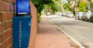 An emergency phone positioned on a brick wall.