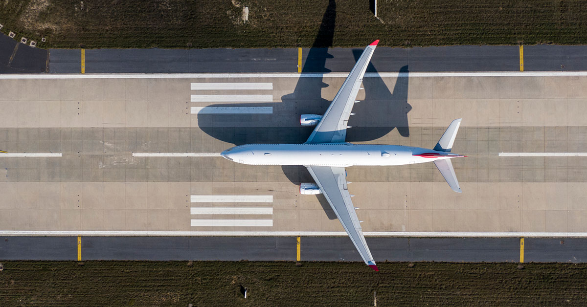 An airplane moves down the runway on an airfield.