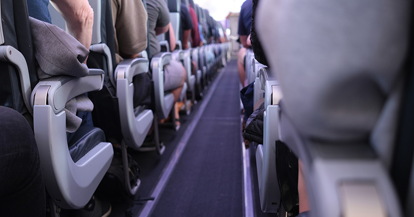 A view of the center aisle inside the cabin of an aircraft.