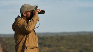 A man views a landscape through binoculars.