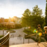 Two students walk down a stairway on the middle of campus.