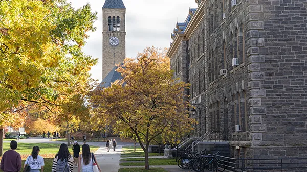 Students walking through a university campus during early autumn.